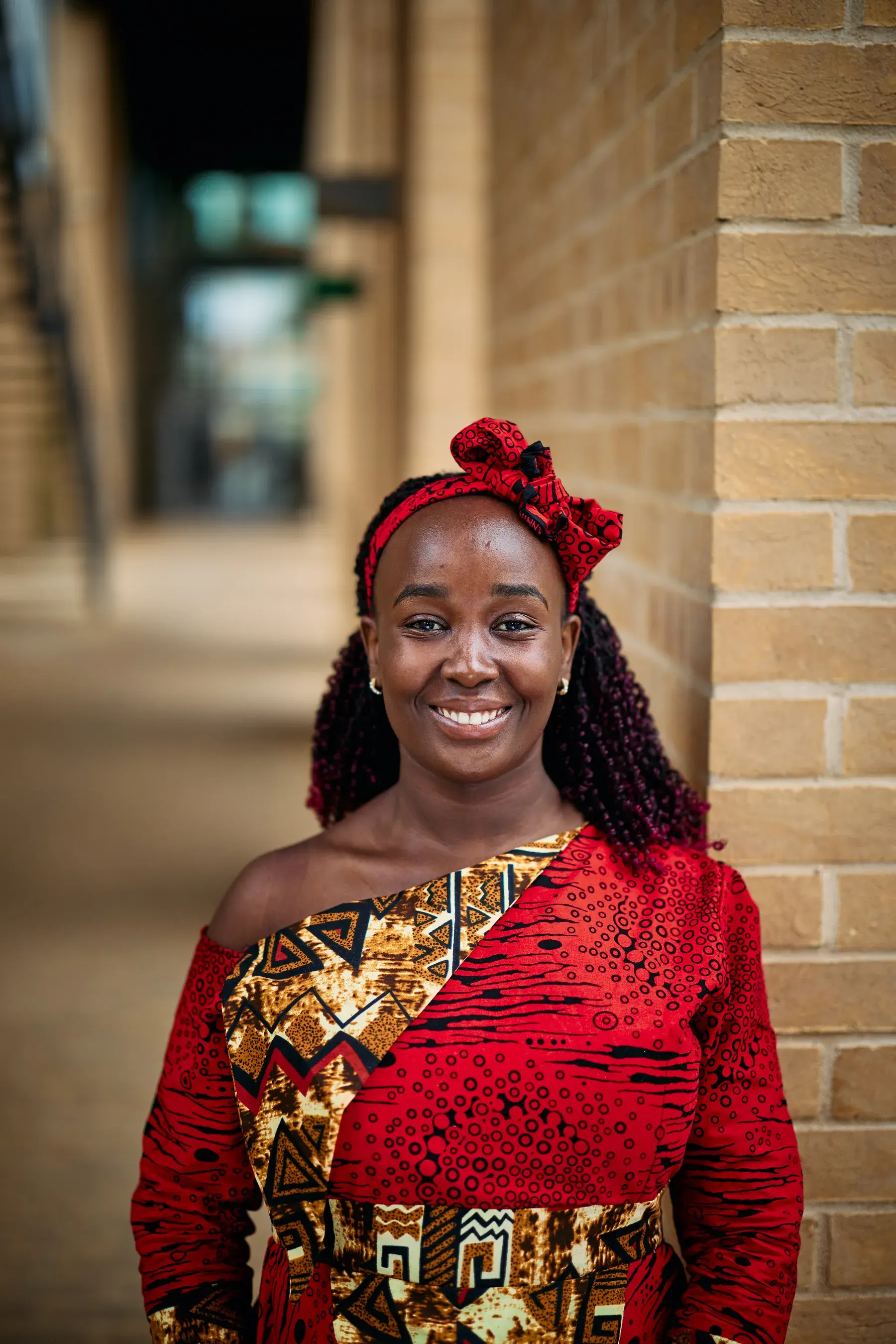Portrait of Ruth Nanjala smiling in a red patterned outfit
